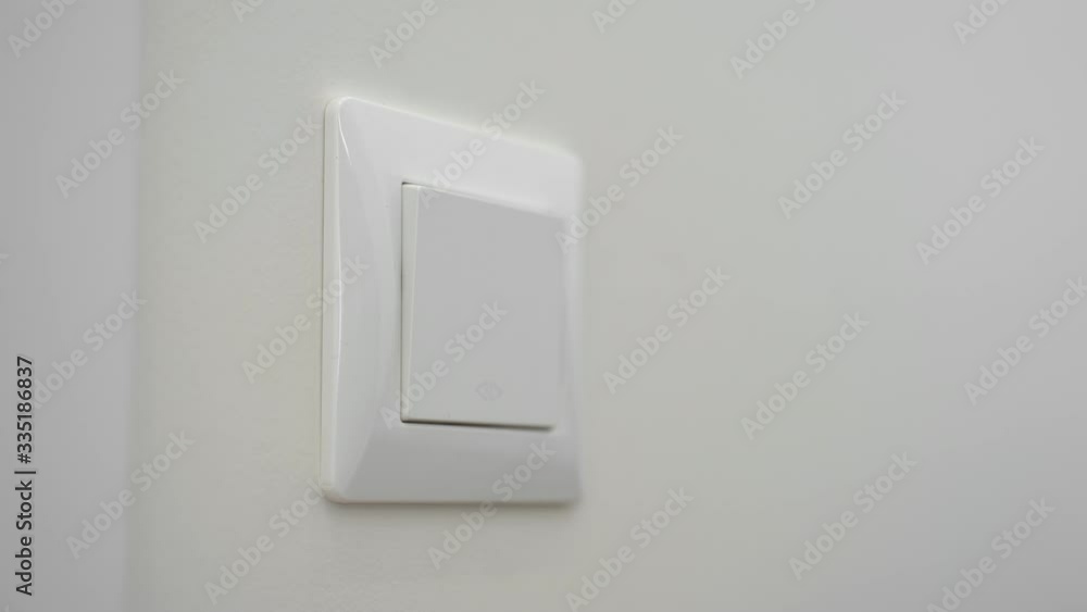 Close up of woman sanitizing light switch at home with alcohol wet wipe. Covid-19 spread prevention Close up of woman sanitizing light switch at home with alcohol wet wipe. Covid-19 spread prevention