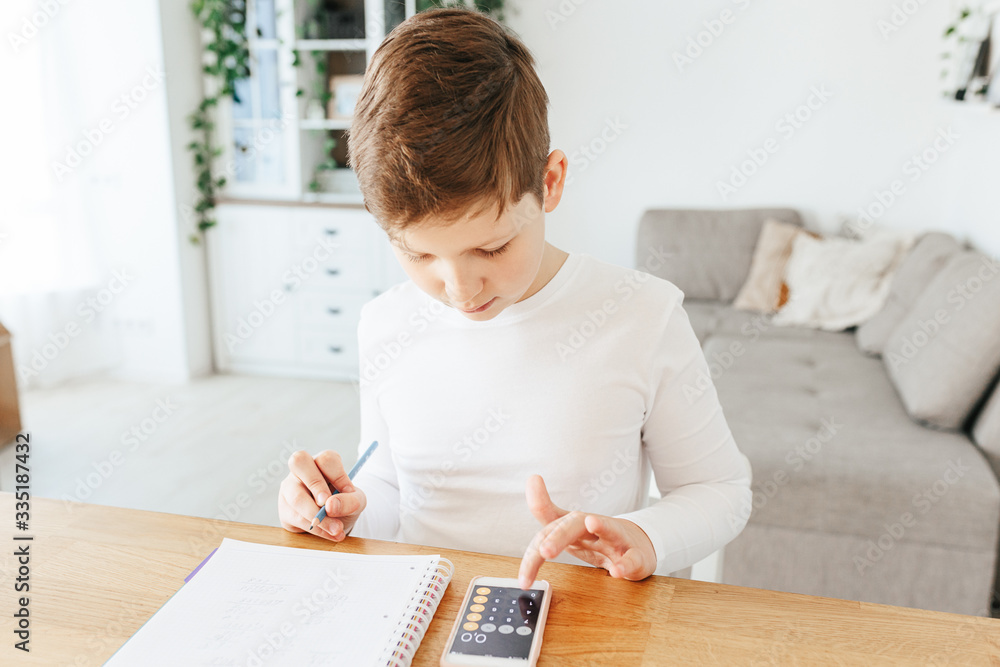 Healthy child writing with pen, staying at home. Homeschooling concept Healthy child writing with pen, staying at home. Homeschooling concept