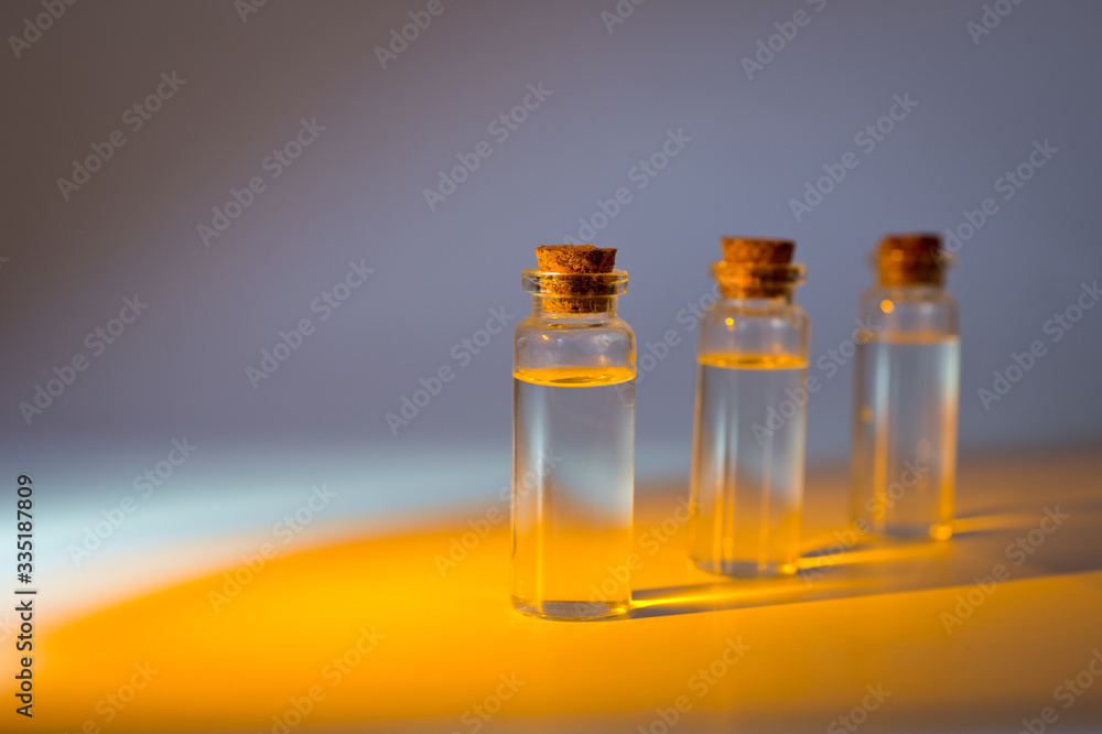 Three glass corked bottles filled with liquid. Background for science and medicine. Virus vaccine. Three glass corked bottles filled with liquid. Background for science and medicine. Virus vaccine.
