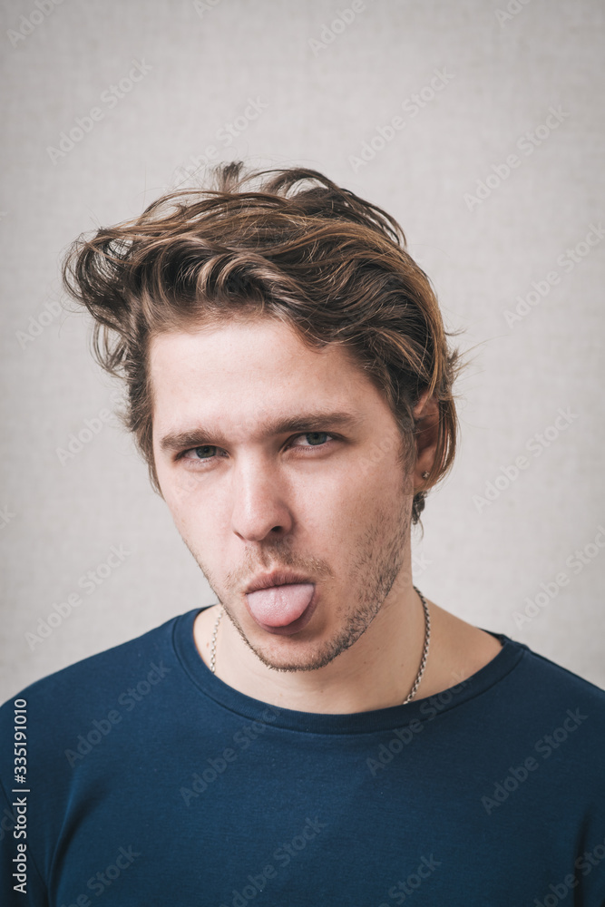 portrait of a young man showing his tongue portrait of a young man showing his tongue
