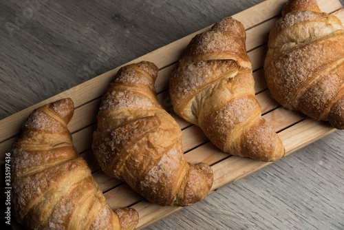 Colazione cornetti con un background grigio serviti su un piatto di legno