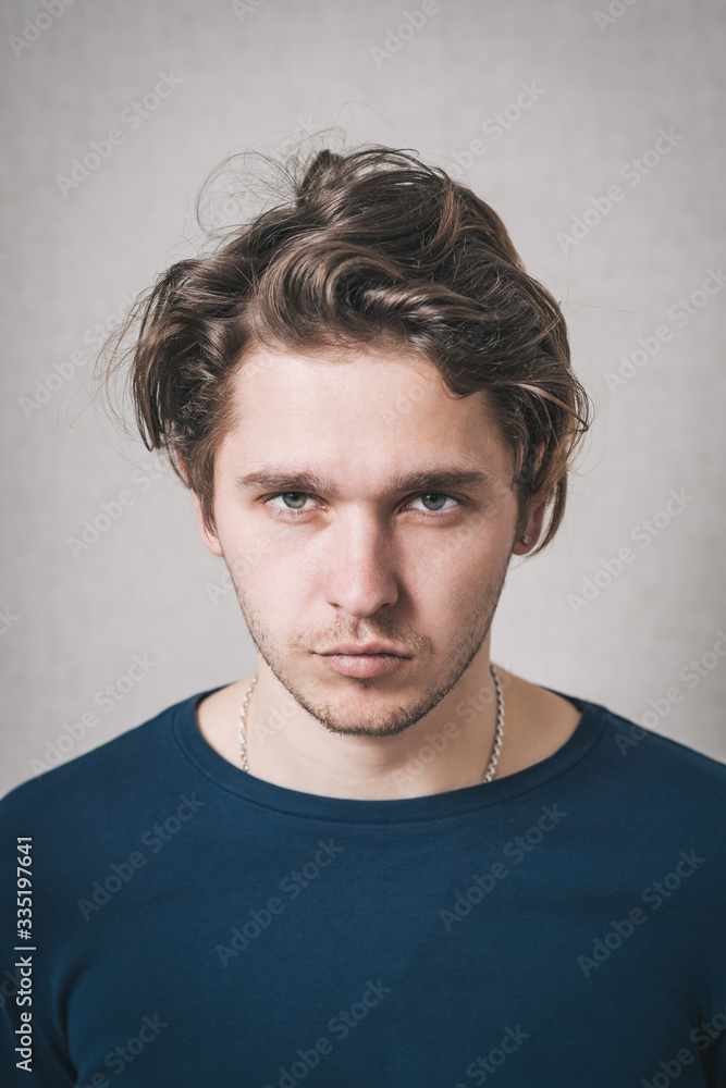 Man grimaces. Gray background Man grimaces. Gray background