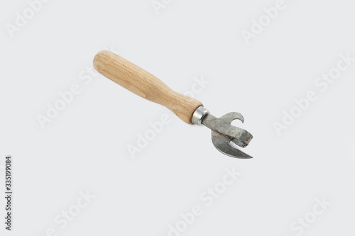 An iron knife with a wooden handle for opening canned food isolated on a white background. © fotosidorenko
