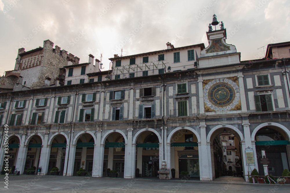 Arcades and clock tower in Piazza della Loggia, Brescia, Lombardy, Italy.