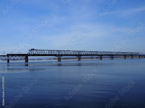 Foto Railway bridge over the river. Sunny spring day.