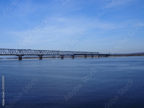 Railway bridge over the river. Sunny spring day. © Yulia