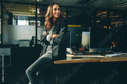 Smiling businesswoman sitting on her desk