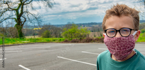 child wearing anti virus mask, outdoors photo