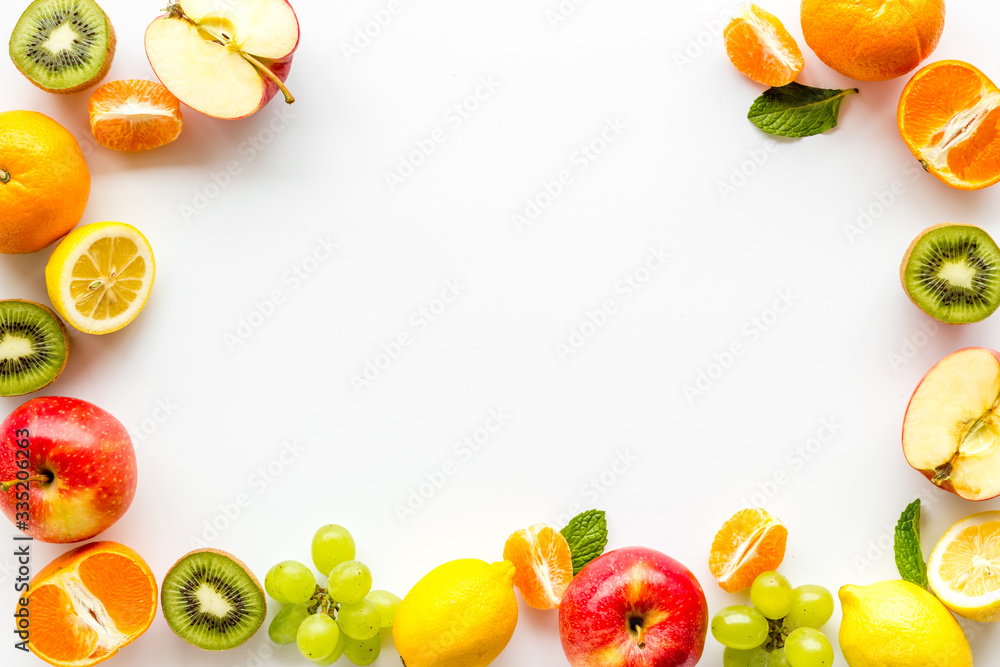 Oranges, lemon, apple, kiwi and grape - healthy food concept with fruits - on white background top-down frame copy space Oranges, lemon, apple, kiwi and grape - healthy food concept with fruits - on white background top-down frame copy space