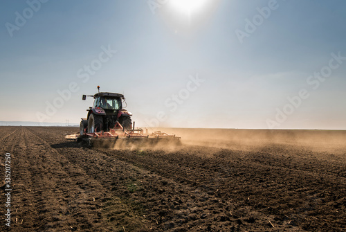 Tractor is preparing the land at dusk