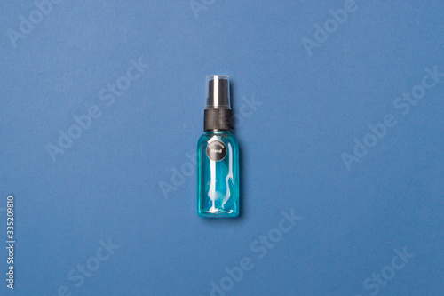 alcohol clean hand sanitizer in bottle on blue colored paper background