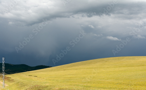 Picturesque mountains and hills on a cloudy day against the background of dark clouds. Mongolia