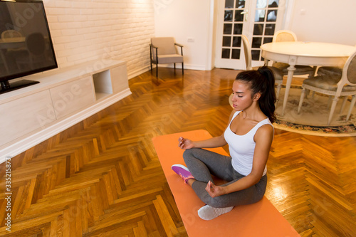 Young woman practicing yoga...