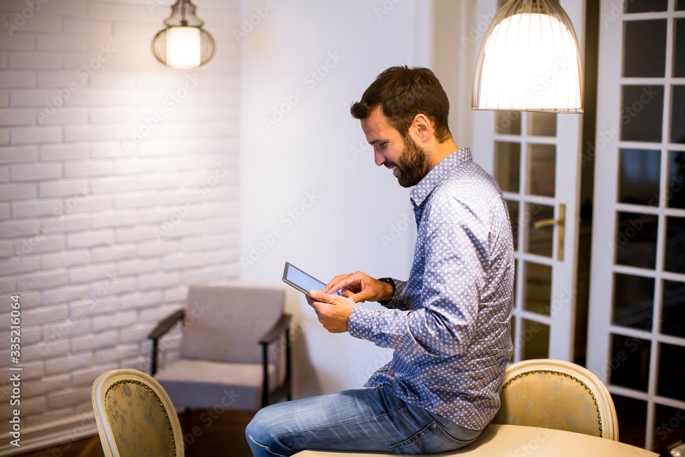 Young man working from home on digital tablet
