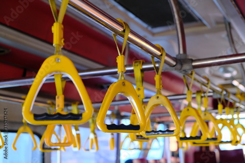 Yellow plastic handles on a metal handrail on the bus.