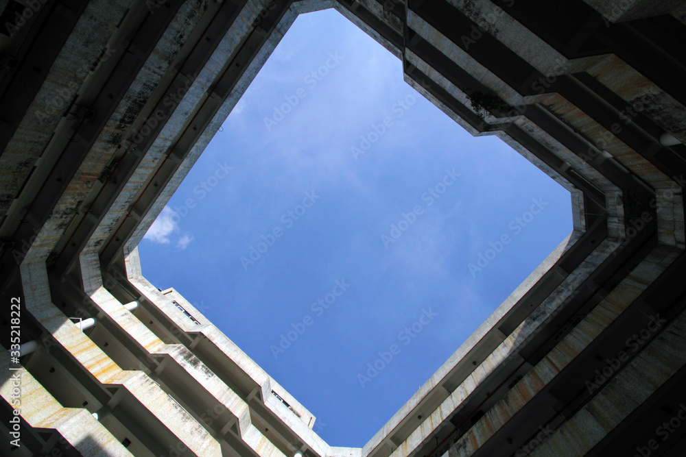 Standing in the surrounding high-rise buildings, looking up at the blue sky and white clouds at the top