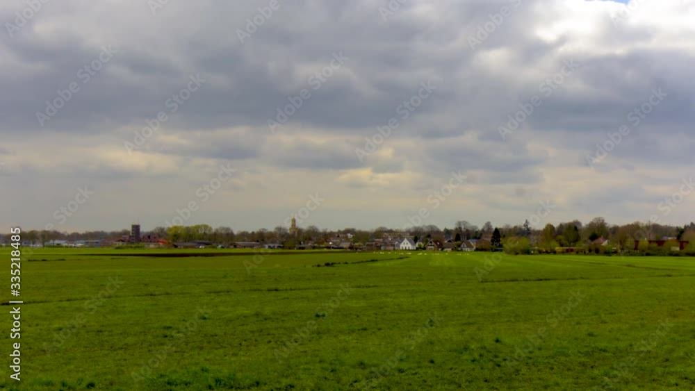 Time lapse of clouds and cloud rays passing over skyline of typical Dutch rural town Time lapse of clouds and cloud rays passing over skyline of typical Dutch rural town