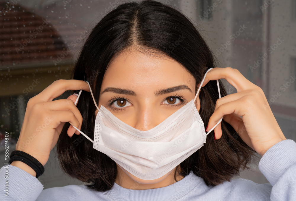 Young woman wearing a mask to protect herself against the coronavirus while going out. Close-up photo. Young woman wearing a mask to protect herself against the coronavirus while going out. Close-up photo.