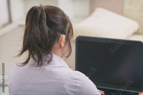 Hearing impaired woman working with laptop photo