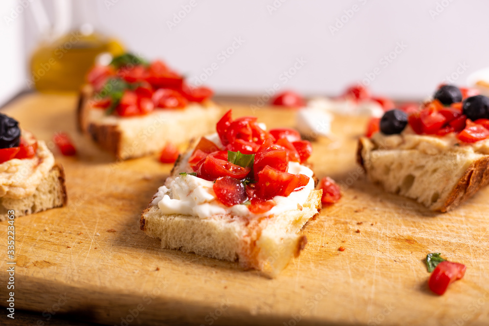 Mix of bruschette with cherry tomatoes and cream cheese, hummus and black olives. Italian food, healthy appetizer Mix of bruschette with cherry tomatoes and cream cheese, hummus and black olives. Italian food, healthy appetizer