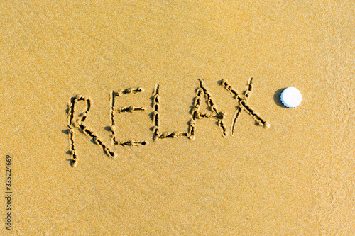 Relax written on a sandy beach.
