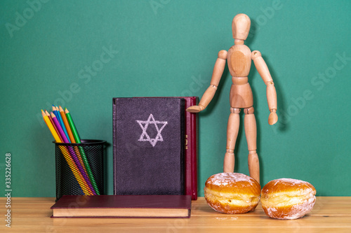 Wooden man next to a religious book and Sufgania photo