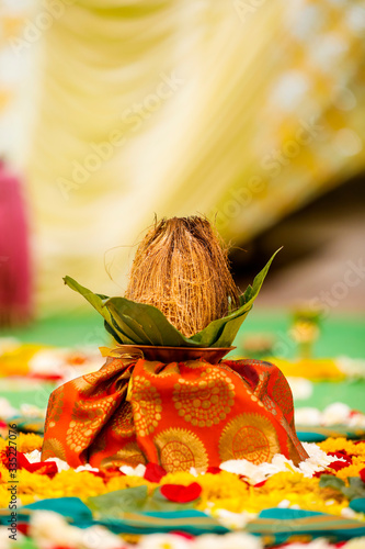 Indian wedding ceremony : decorative coper kalash with green leaf and coconut photo