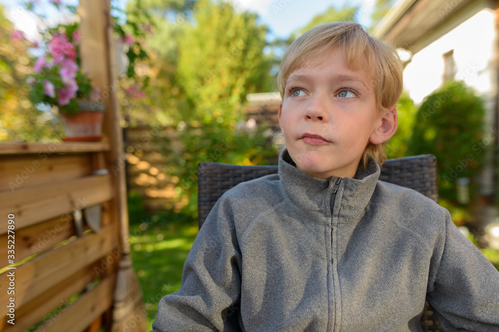 Young handsome boy thinking and looking up in the backyard Young handsome boy thinking and looking up in the backyard