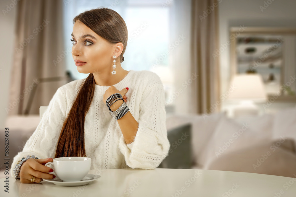 Slim young woman in home interior with blurred window and white table of free space for your decoration. Slim young woman in home interior with blurred window and white table of free space for your decoration.