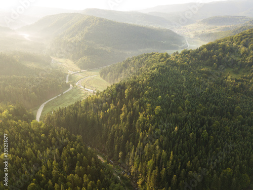 Road through mountains and forest captured from above