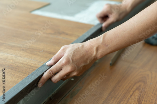 close up of working  hands matching floor nosing color for vinyl floor tile step 