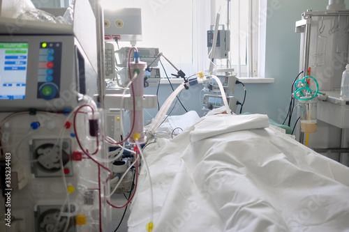 Patient with coronavirus infection in critical stance.Intensive care emergency room with hemodialysis machine or hemofiltration procedure.