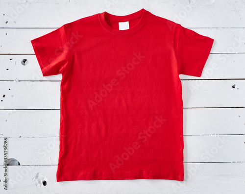 Red t-shirt on white wooden background