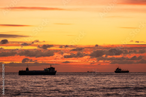 Sunset over the sea. A naval ship on the horizon. Oil tanker ship at sea on a background of sunset sky © Ivan_vislov_nadsochi