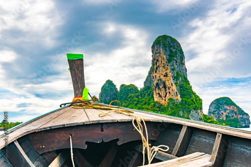 View from boat going to famous Railay beach, Krabi Thailand. Coastline of Andaman sea, famous tourist and backpacker target. Tropical paradise, exotic vacation. Cloudy weather in summer day photo