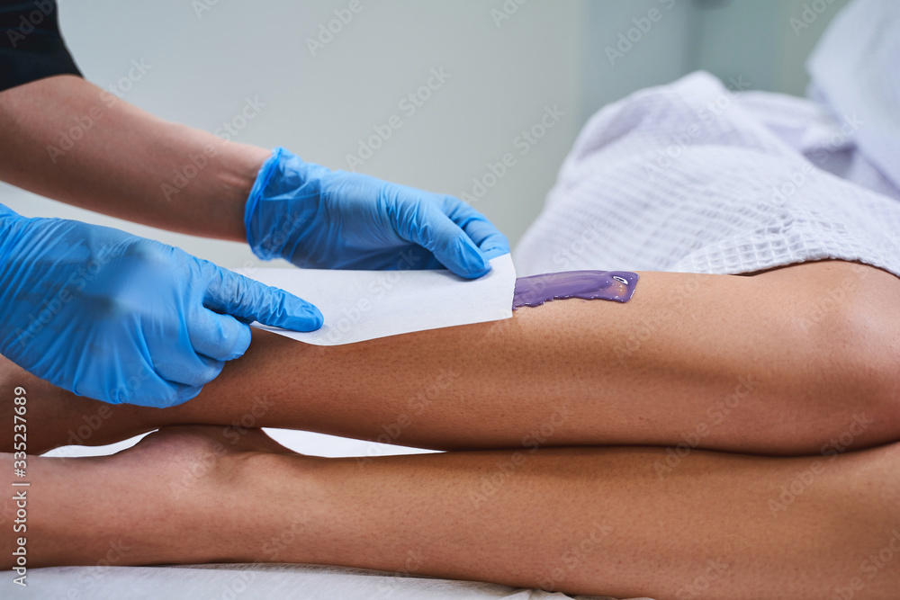 Cropped photo of specialist during waxing procedure stock photo