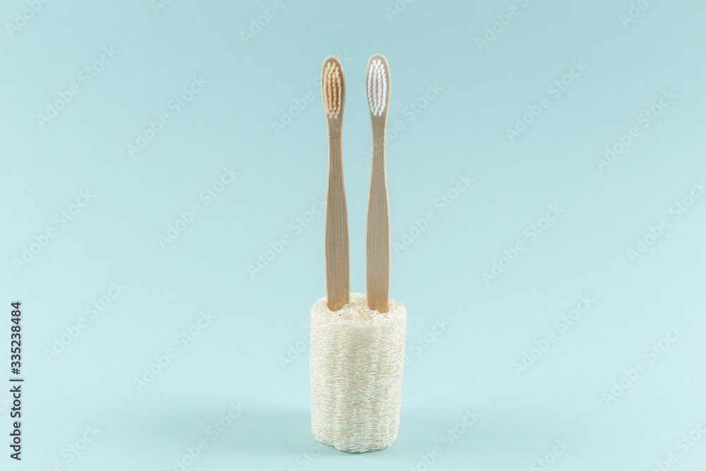 Two environmentally friendly toothbrushes are in ecological packaging. Zero waste. On a blue background. Two environmentally friendly toothbrushes are in ecological packaging. Zero waste. On a blue background.
