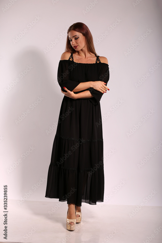 Beautiful woman in black dress on bright background Beautiful woman in black dress on bright background