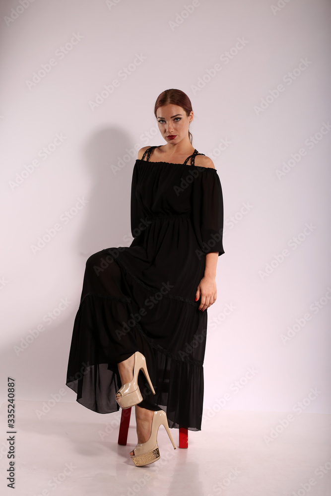 Beautiful woman in black dress on bright background Beautiful woman in black dress on bright background