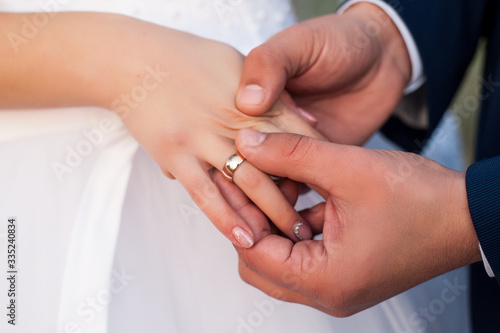  on the wedding day, the husband puts on a wedding ring to the bride in a white dress and it is happiness when two lovers' hearts are united in a family