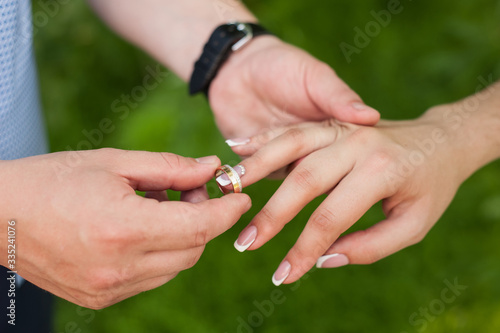  on the wedding day, the husband puts on a wedding ring to the bride in a white dress and it is happiness when two lovers' hearts are united in a family