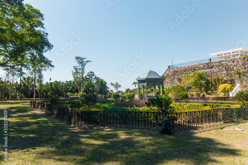 Victoria Peaks gardens, Hong Kong Island, China. Chinese style garden near the summit of Victoria Peak in Hong Kong. Beautiful sunny day with people chilling on the grass.