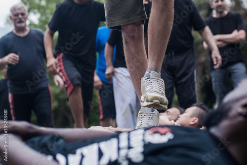 Civilian people trample over crowd lie on ground. Boot camp