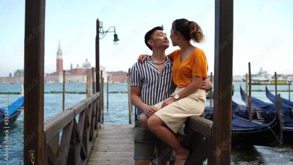 Portrait of a beautiful young Asian couple kissing on vacation in ...