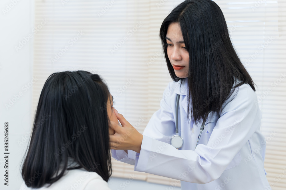 Young Asian female doctor holds adult female patient’s hand to examine and diagnose her sickness and symptom. Medicine and health care concept. Doctor and patient. Young Asian female doctor holds adult female patient’s hand to examine and diagnose her sickness and symptom. Medicine and health care concept. Doctor and patient.