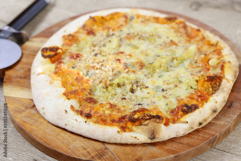 pizza aux gorgonzola et noisettes sur une planche à découper pizza aux gorgonzola et noisettes sur une planche à découper