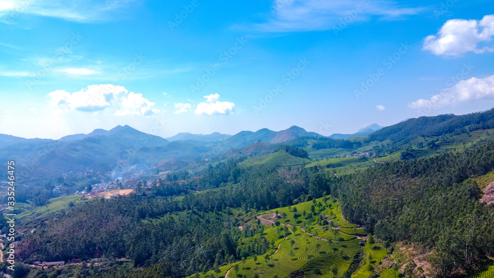 Tea plantations in Munnar, Kerala, India. Beautiful views of green hills with blue sky.