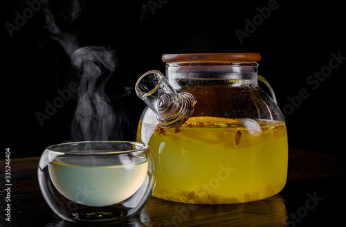 tea pot and Cup of ginger tea with honey and lemon on black background