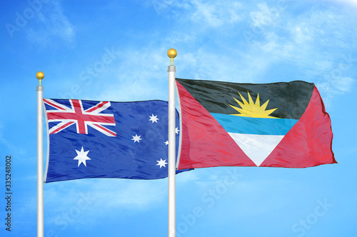 Australia and Antigua and Barbuda two flags on flagpoles and blue cloudy sky photo