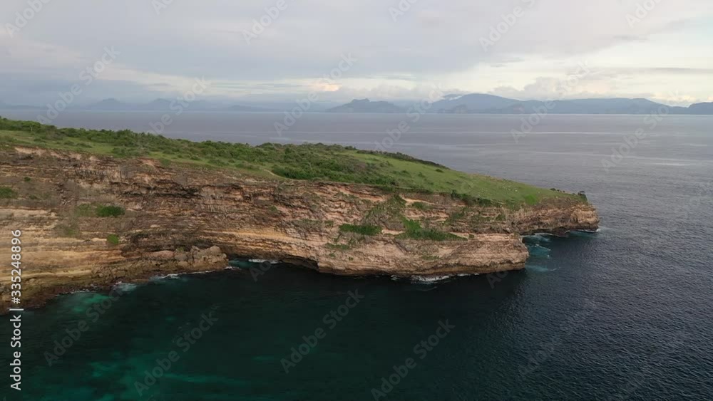 Lombok Island, Indonesia - Beautiful Nature Scenery Of The Lush Rocky Cliff Of Tanjung Sabui Surrounded By The Big Blue Sea - Aerial Shot Lombok Island, Indonesia - Beautiful Nature Scenery Of The Lush Rocky Cliff Of Tanjung Sabui Surrounded By The Big Blue Sea - Aerial Shot
